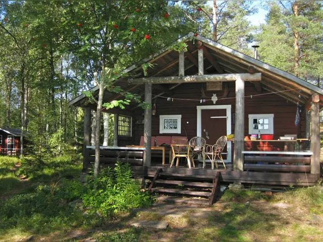 Stuga med terrass bland träden